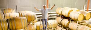 Winemaker Rick Hutchinson about to draw wine from the barrel using a "wine thief"